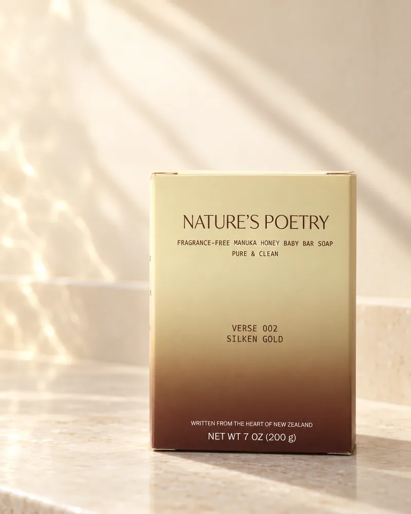 The Verse 002 Silken Gold carton, butter-gold fading to brown, on a stone step in morning light.